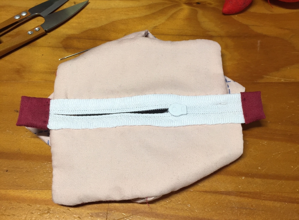Almost finished pouch 16, showing the burgundy zipper tabs and the pink lining