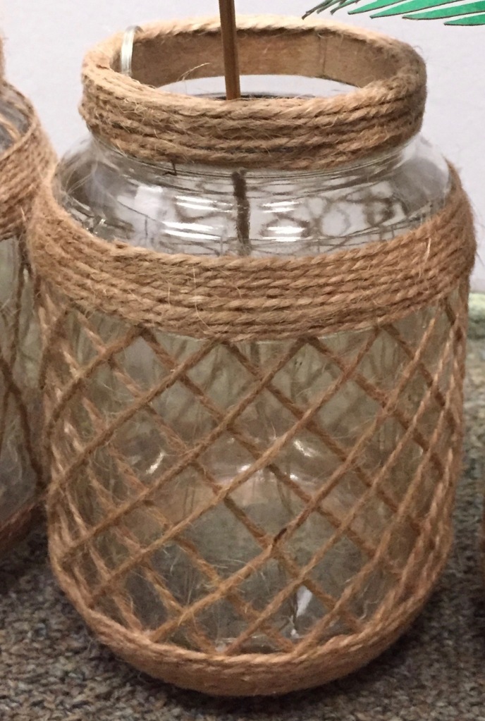 The lattice over the body of the jar is basic diamonds formed by single strands of jute crossing diagonally from a top band of twine to a bottom band, in both directions. There's significant space from the top band of twine to the band covering the thread at the mouth of the jar.